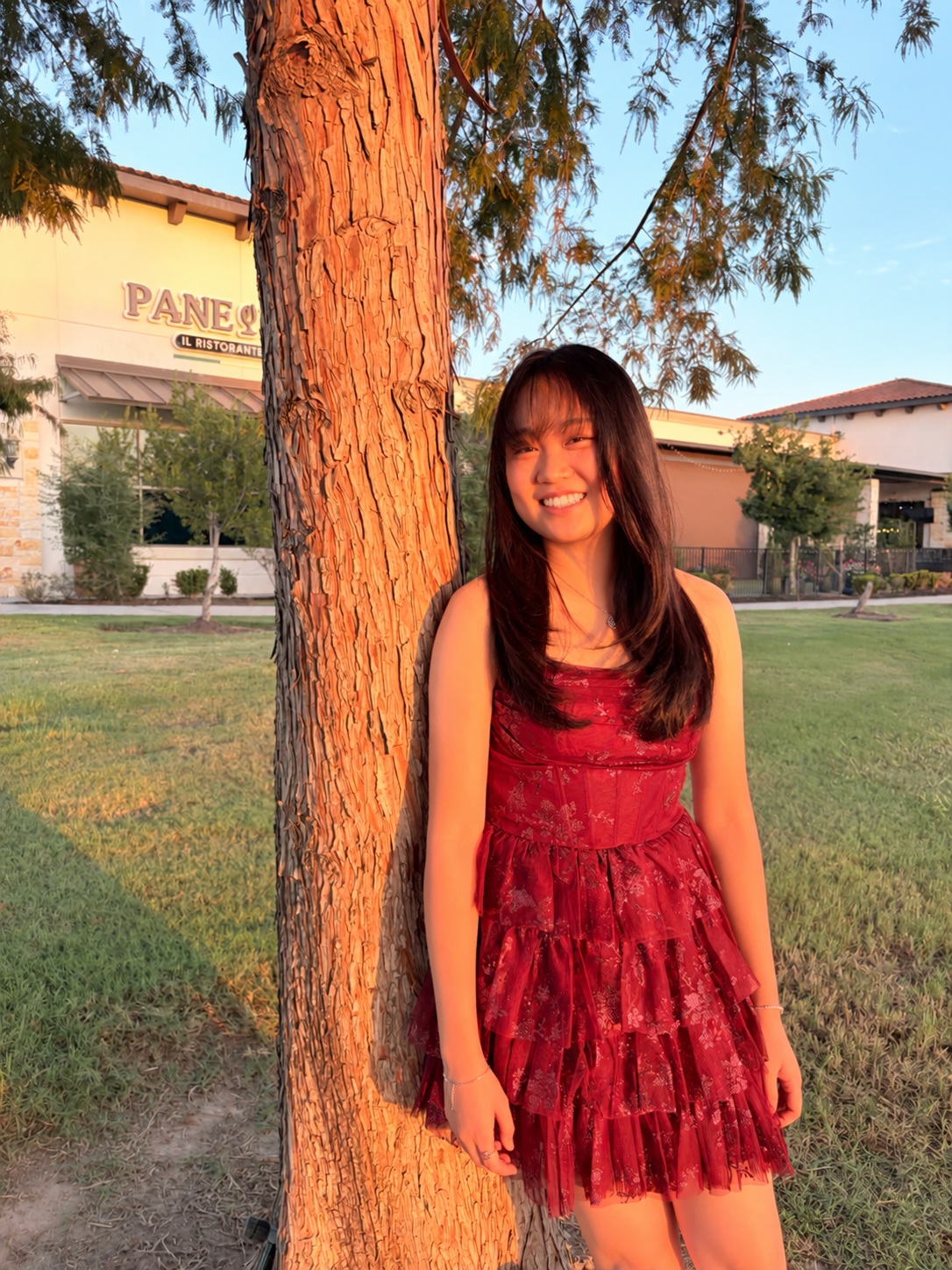 Gracelynn smiling beside a tree in the evening sunlight